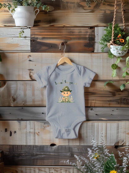 a baby bodysuit hanging on a wooden wall