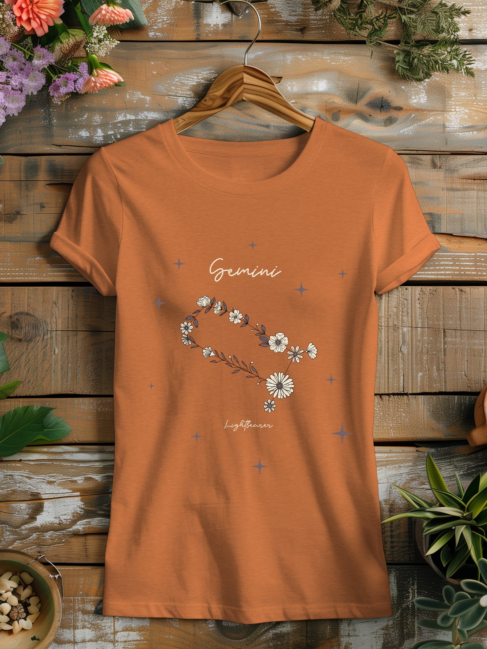 an orange t - shirt with a picture of a flower on it