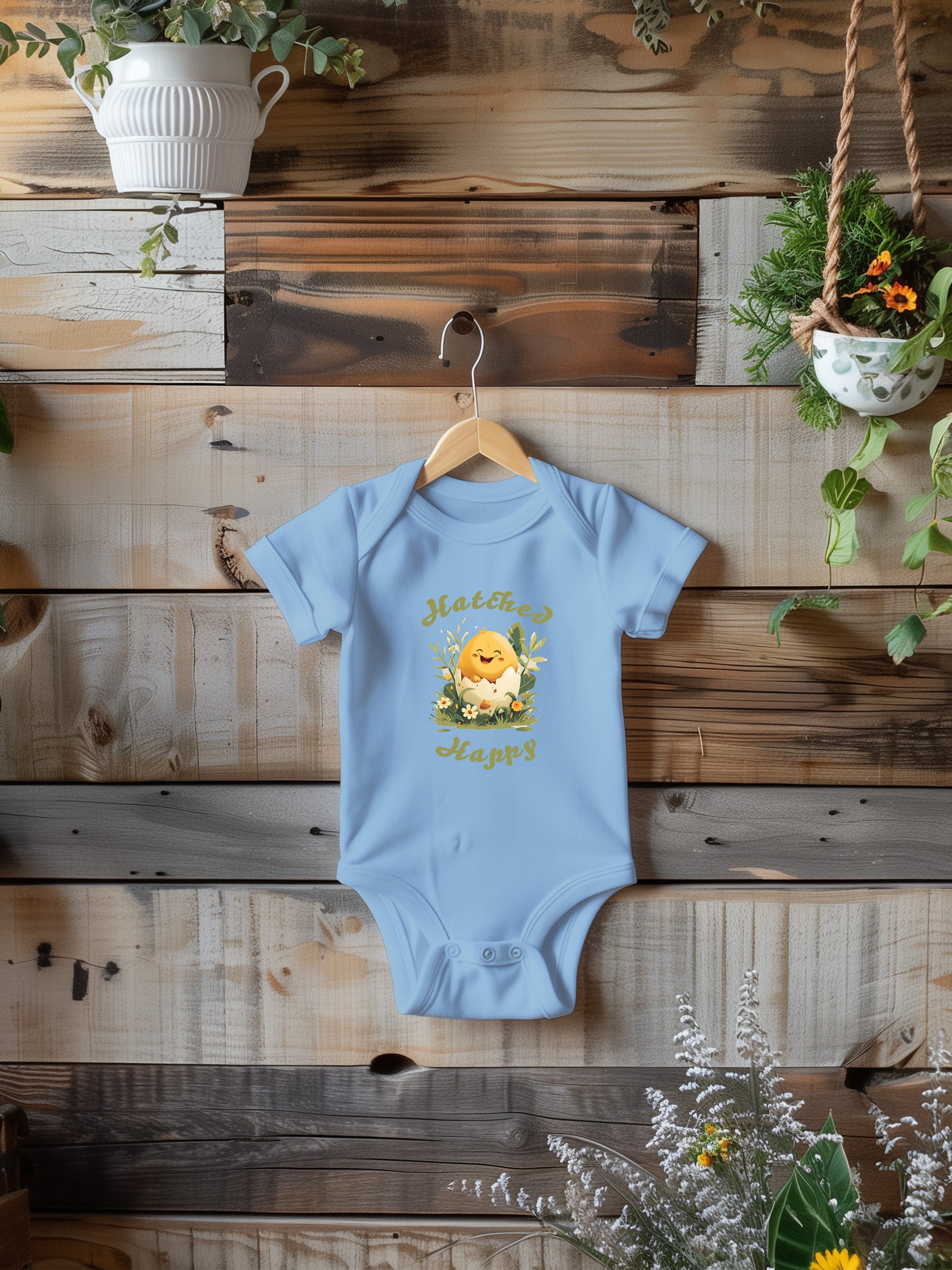 Baby Onesie with a smiling chick in an egg shell with text hatched happy.