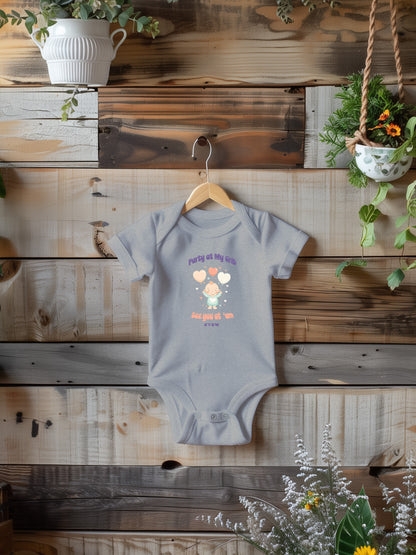 a baby bodysuit hanging on a wooden wall