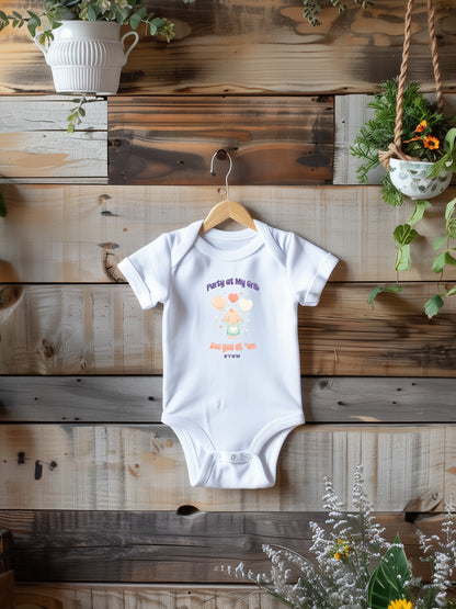 a baby bodysuit hanging on a wooden wall