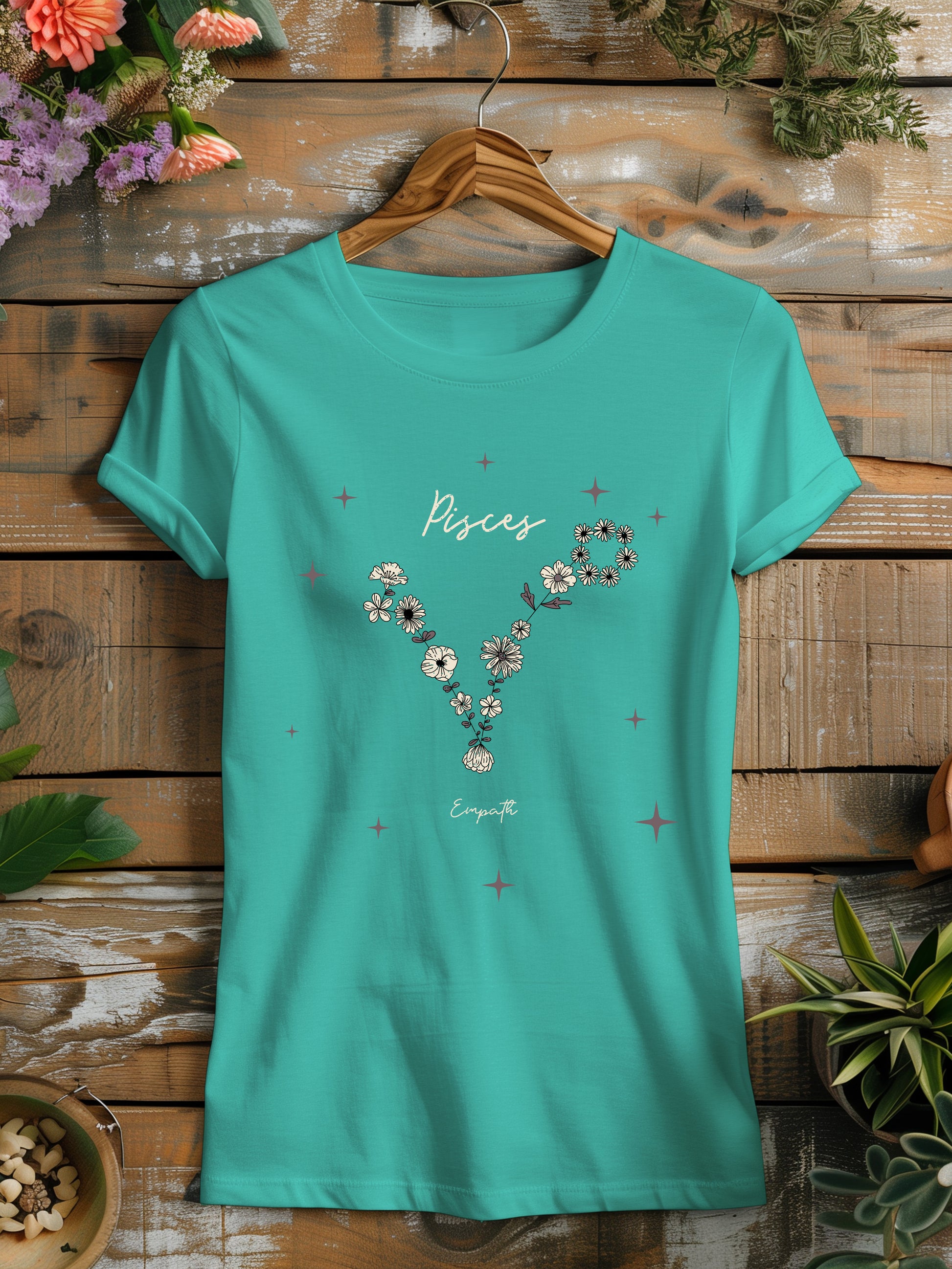 a turquoise t - shirt with flowers on it