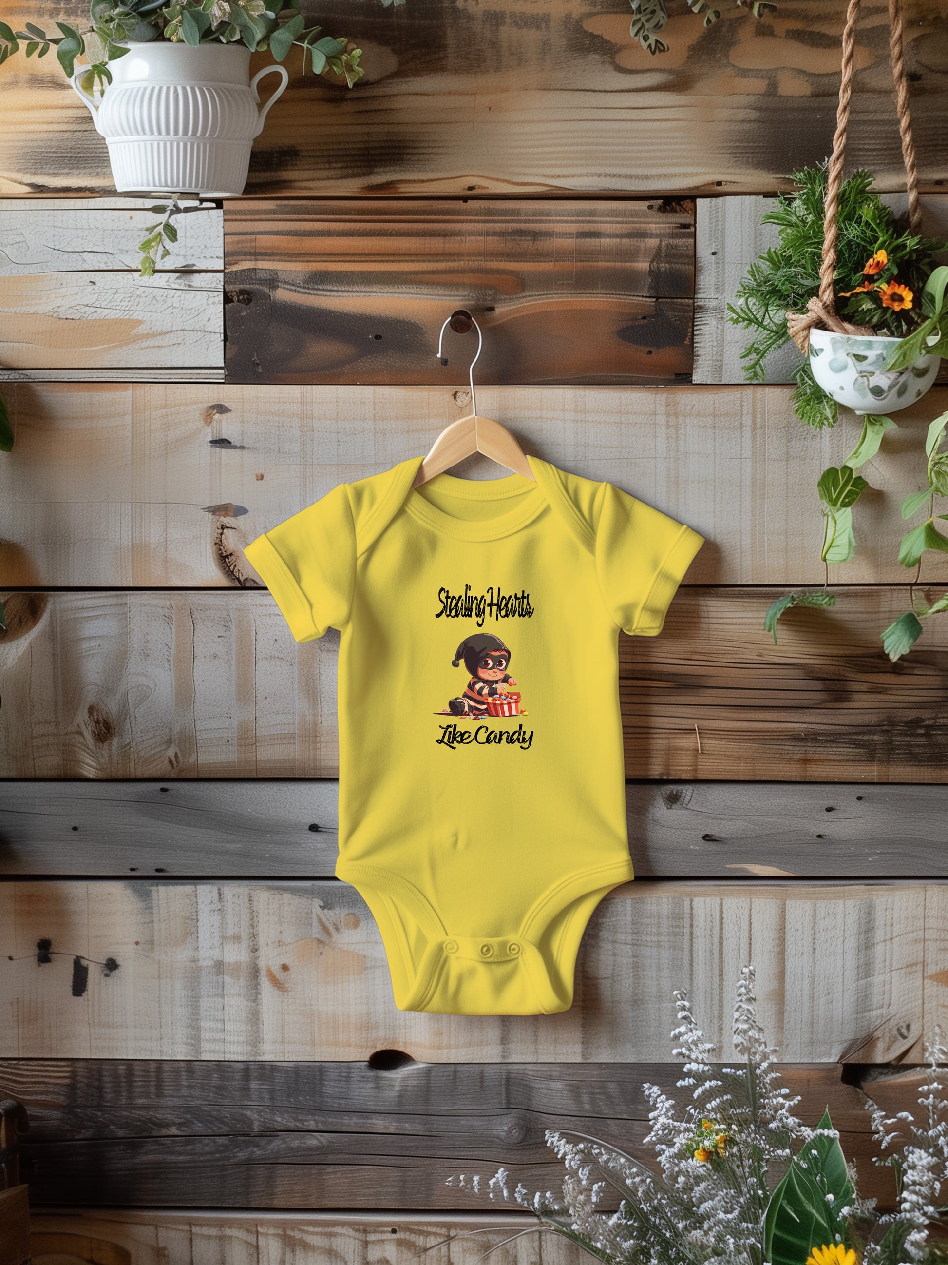 a baby bodysuit hanging on a wooden wall