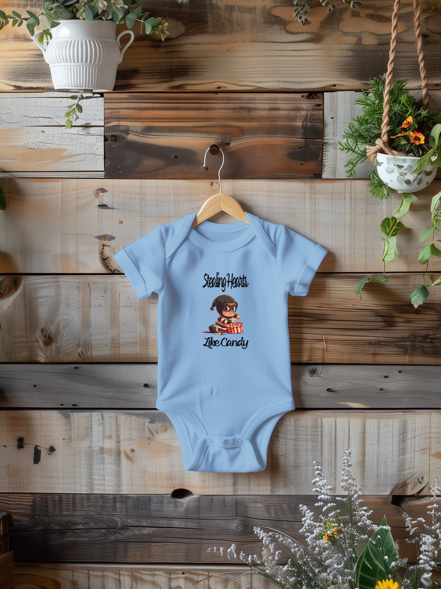 a baby bodysuit hanging on a wooden wall