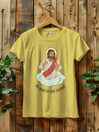 t-shirt with a cartoon of Jesus giving thumbs up, hanging on a wooden hanger against a wooden background.