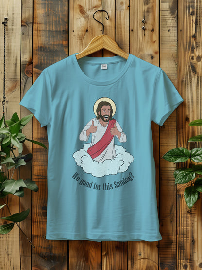 t-shirt with a cartoon of Jesus giving thumbs up, hanging on a wooden hanger against a wooden background.