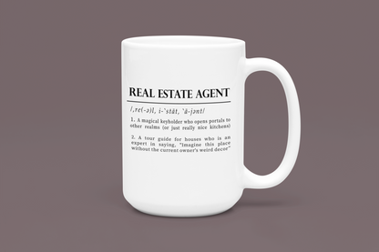 A classic white ceramic mug features a playful definition of 'Real Estate Agent' printed in elegant black font. The text humorously describes the agent as a keyholder to realms and an expert in home decor imagination. 