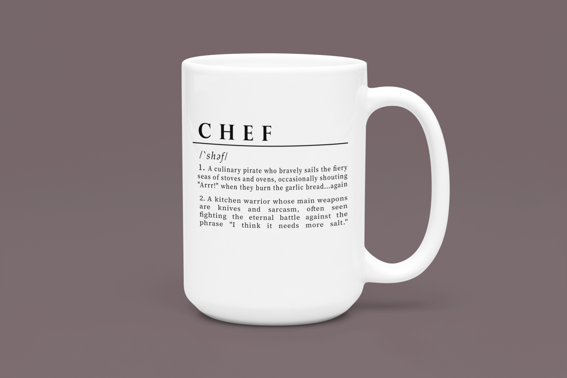 A white ceramic mug with a playful and humorous definition of 'Chef', printed in sharp black lettering. The text describes a chef as a culinary pirate and a kitchen warrior, humorously highlighting the challenges and quirks of culinary life. 