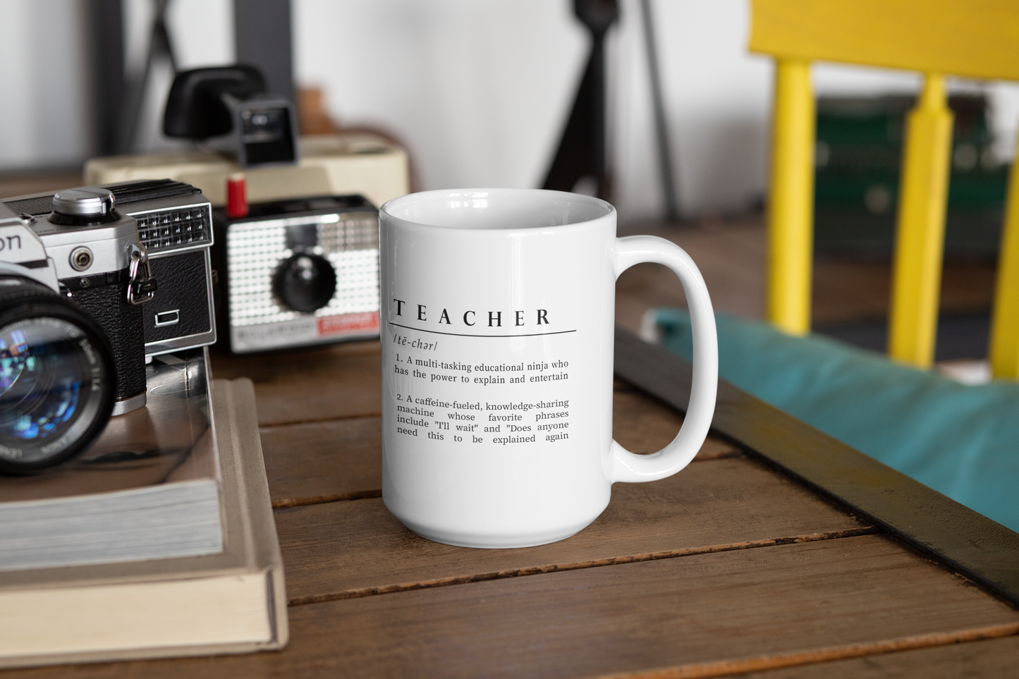 Featured is a white ceramic mug adorned with a clever and affectionate definition of 'Teacher' in black text. The description playfully outlines a teacher as a multitasking educational ninja and a caffeine-fueled knowledge sharer, adding humor to the daily realities of teaching.